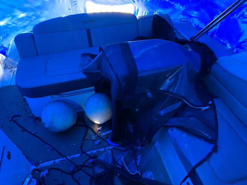 Slide: The Image of 2017 Sea Ray Sundancer 310 interior with seating and marine equipment under blue tarp. - 4