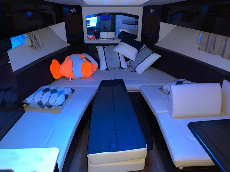 Slide: The Image of 2017 Sea Ray Sundancer 310 cabin interior with plush seating and decorative pillows. - 7