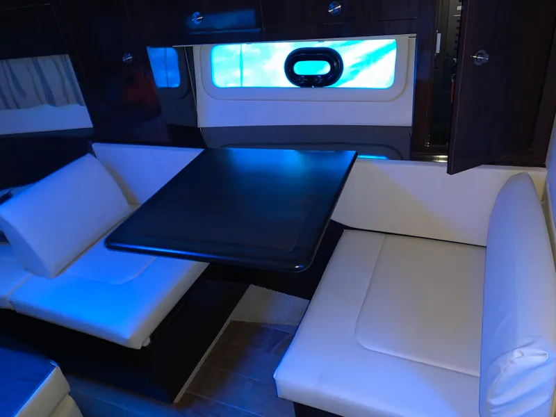 Slide: The Image of Interior of 2017 Sea Ray Sundancer 310 with seating and table, blue ambient lighting. - 8