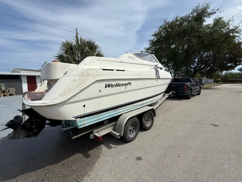 Slide: The Image of 2000 Wellcraft 2400 Martinique boat on trailer, parked outdoors. - 11