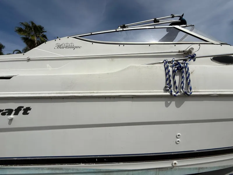 Slide: The Image of 2000 Wellcraft 2400 Martinique boat side view with blue rope and clear sky. - 13