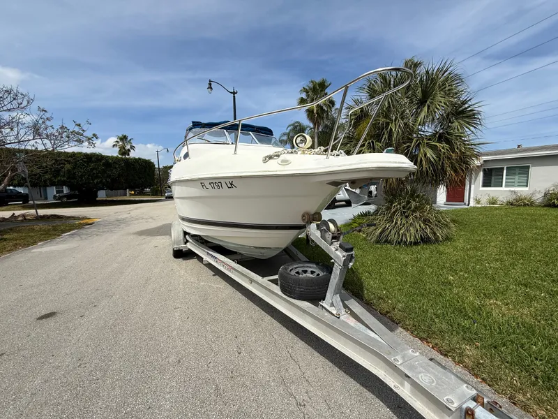 Slide: The Image of 2000 Wellcraft 2400 Martinique boat on trailer, parked on residential street. - 16