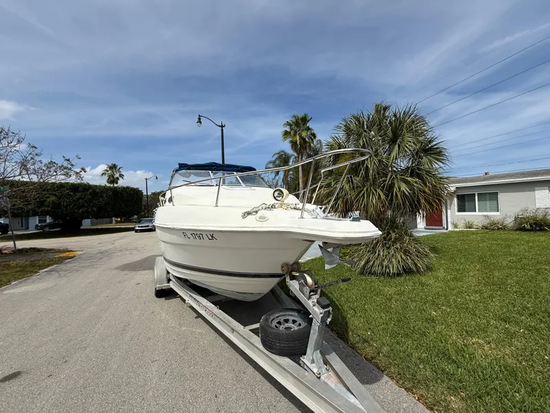 Slide: The Image of 2000 Wellcraft 2400 Martinique boat on trailer, parked in residential area. - 17