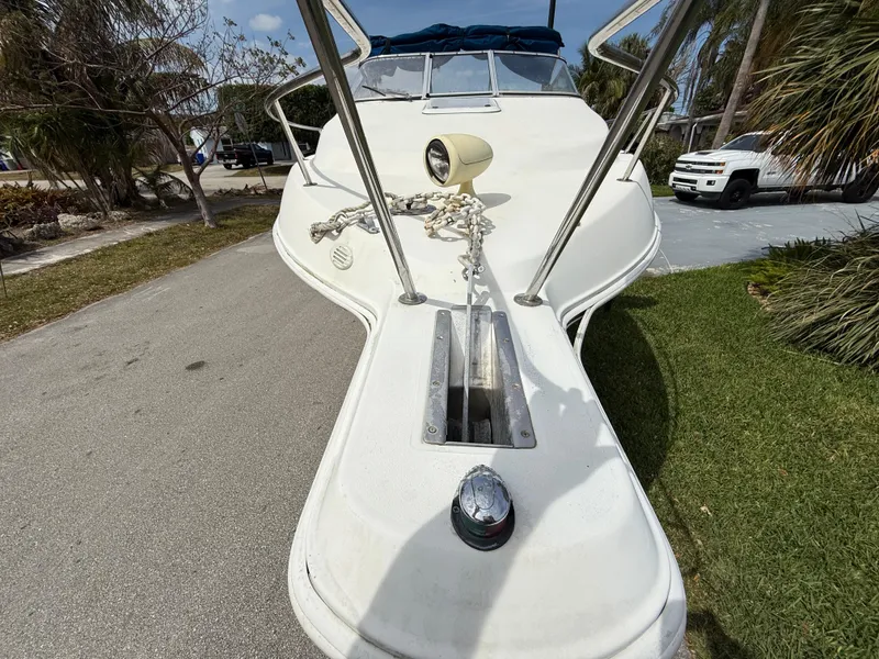 Slide: The Image of 2000 Wellcraft 2400 Martinique boat, docked on a sunny day, with anchor chain visible. - 18