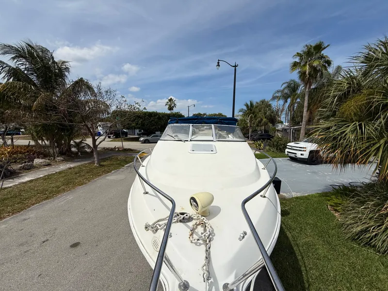 Slide: The Image of 2000 Wellcraft 2400 Martinique boat parked on a sunny street with palm trees. - 20