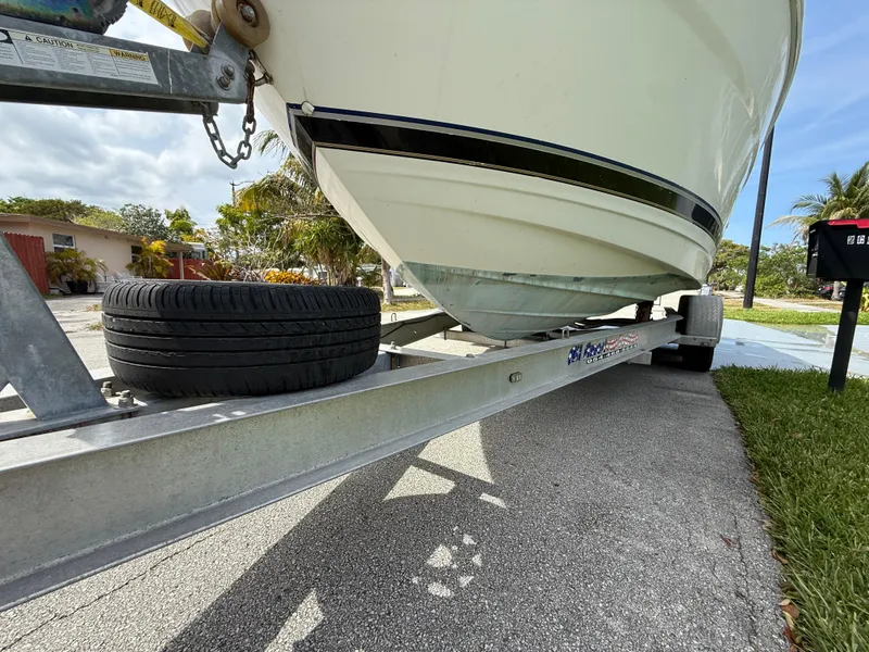 Slide: The Image of 2000 Wellcraft 2400 Martinique boat on trailer, parked on a residential street. - 23