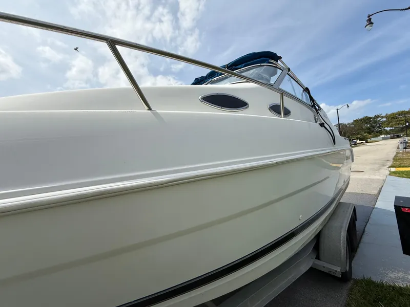 Slide: The Image of 2000 Wellcraft 2400 Martinique boat on trailer under a partly cloudy sky. - 28