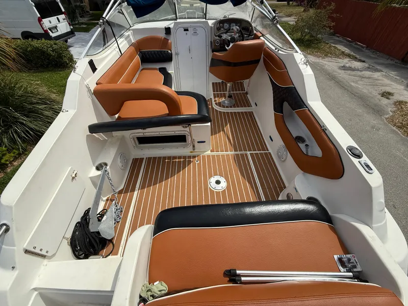 Slide: The Image of 2000 Wellcraft 2400 Martinique boat interior with tan and black seating, wood-style flooring. - 29