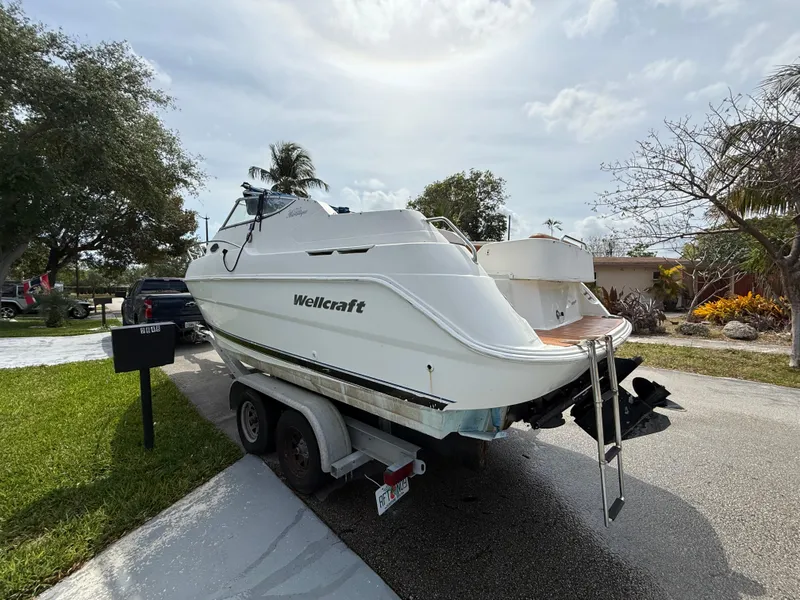 Slide: The Image of 2000 Wellcraft 2400 Martinique boat on trailer, parked in residential area. - 3