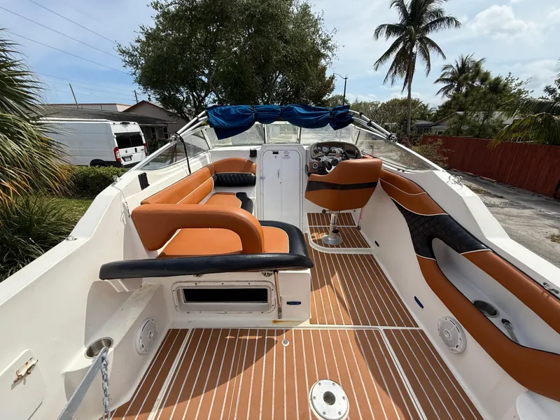 Slide: The Image of 2000 Wellcraft 2400 Martinique boat with tan seating and wood-style flooring, docked outdoors. - 31