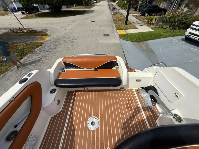 Slide: The Image of 2000 Wellcraft 2400 Martinique boat interior with brown seating and wood-patterned flooring. - 32
