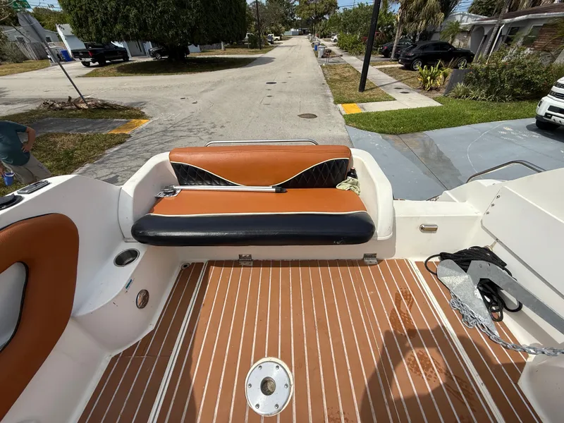 Slide: The Image of 2000 Wellcraft 2400 Martinique boat interior with brown and black seating, wooden deck. - 33