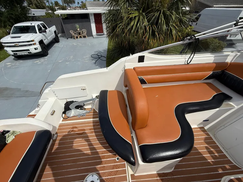 Slide: The Image of 2000 Wellcraft 2400 Martinique boat with tan and black seating, parked near a white truck. - 34