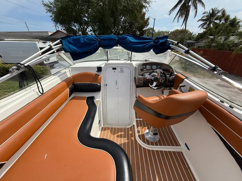 Slide: The Image of 2000 Wellcraft 2400 Martinique boat interior with tan seating and steering console. - 36