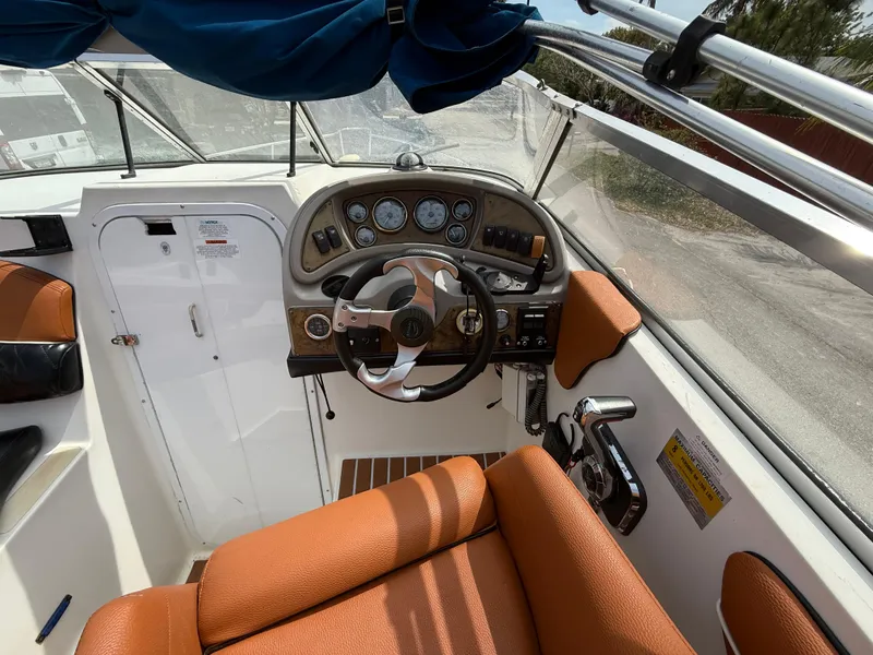 Slide: The Image of 2000 Wellcraft 2400 Martinique boat cockpit with orange seating and steering wheel. - 37