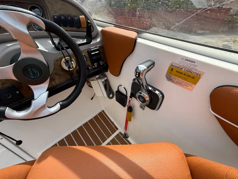 Slide: The Image of Interior of a 2000 Wellcraft 2400 Martinique boat with steering wheel and controls. - 38