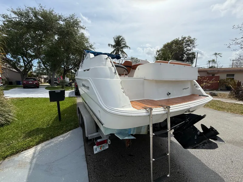 Slide: The Image of 2000 Wellcraft 2400 Martinique boat on trailer, parked in residential area. - 4