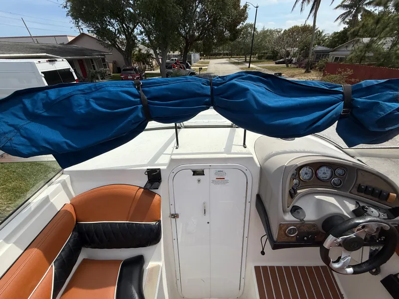 Slide: The Image of 2000 Wellcraft 2400 Martinique boat interior with blue cover and tan seating. - 42