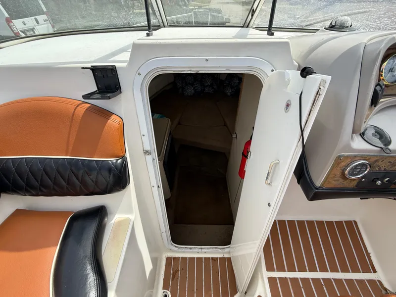 Slide: The Image of 2000 Wellcraft 2400 Martinique boat interior with open cabin door, orange and black seating. - 44