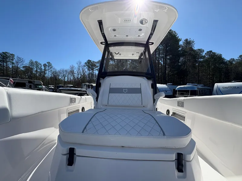 Slide: The Image of 2024 Sea Fox 268 Commander boat interior with cushioned seating and canopy, parked outdoors. - 16