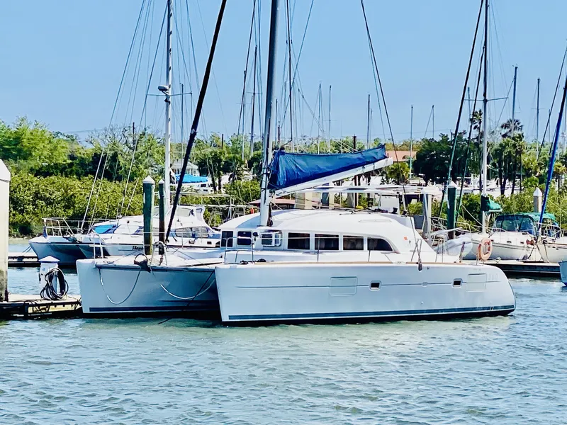 The Image of 2014 Lagoon 380 S2 catamaran docked in a sunny marina. - 0