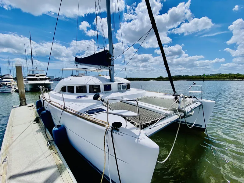 The Image of 2014 Lagoon 380 S2 catamaran docked under a bright blue sky. - 1