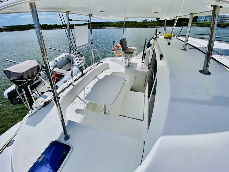 Slide: The Image of 2014 Lagoon 380 S2 catamaran deck with seating, docked by calm waters. - 11