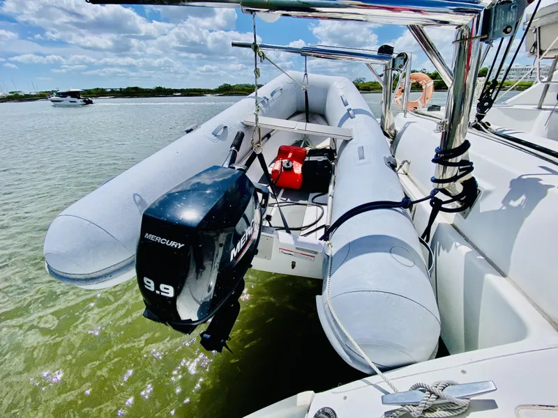 Slide: The Image of Inflatable boat with Mercury 9.9 motor on Lagoon 380 S2, 2014 model, in shallow water. - 12