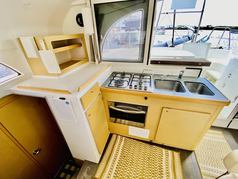 Slide: The Image of Compact kitchen in a 2014 Lagoon 380 S2 catamaran with stove, sink, and storage. - 15