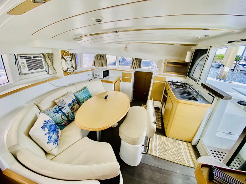Slide: The Image of Interior of 2014 Lagoon 380 S2 catamaran with cozy seating, kitchen, and nautical decor. - 21