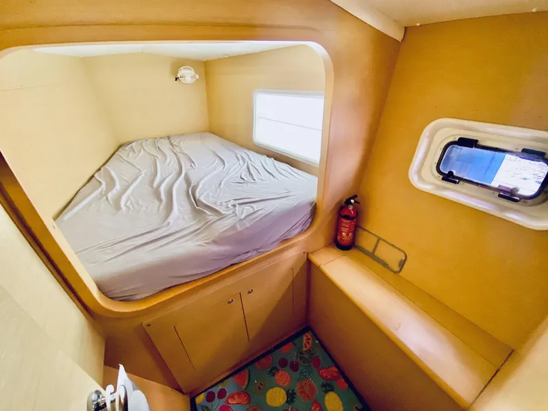 Slide: The Image of Cozy cabin interior of 2014 Lagoon 380 S2 catamaran with bed and porthole window. - 27