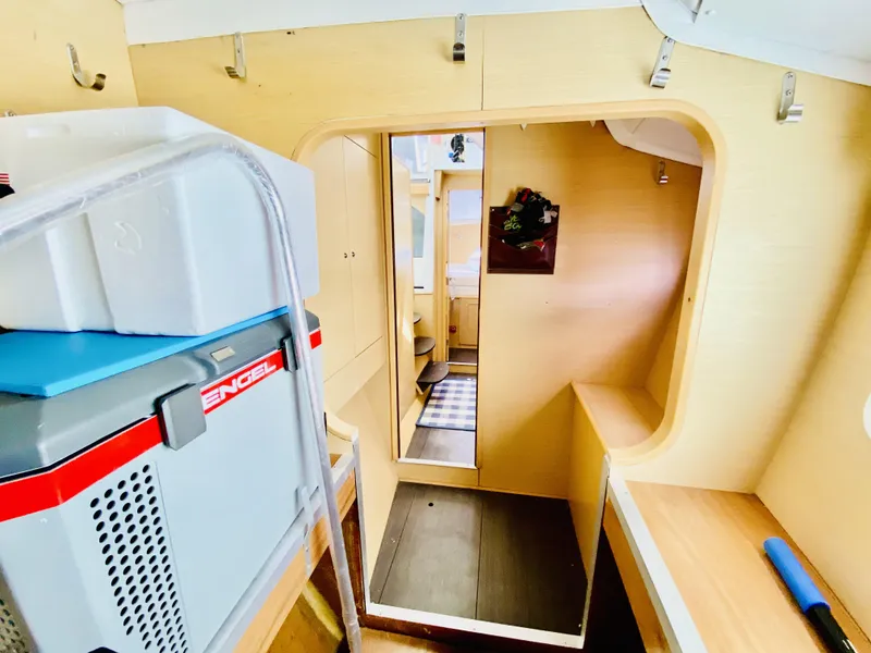 Slide: The Image of Interior of a 2014 Lagoon 380 S2 catamaran, featuring compact storage and light wood finishes. - 33