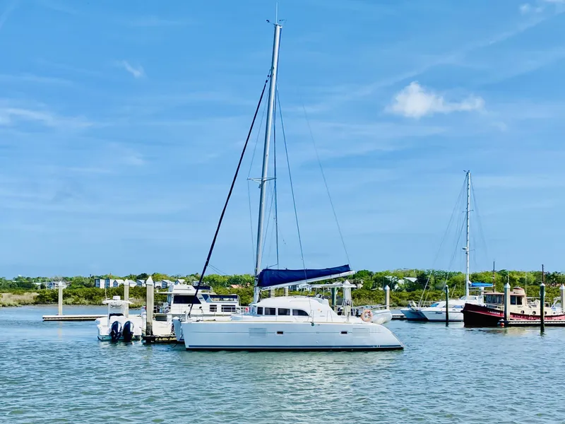 Slide: The Image of 2014 Lagoon 380 S2 catamaran docked in a sunny marina. - 4
