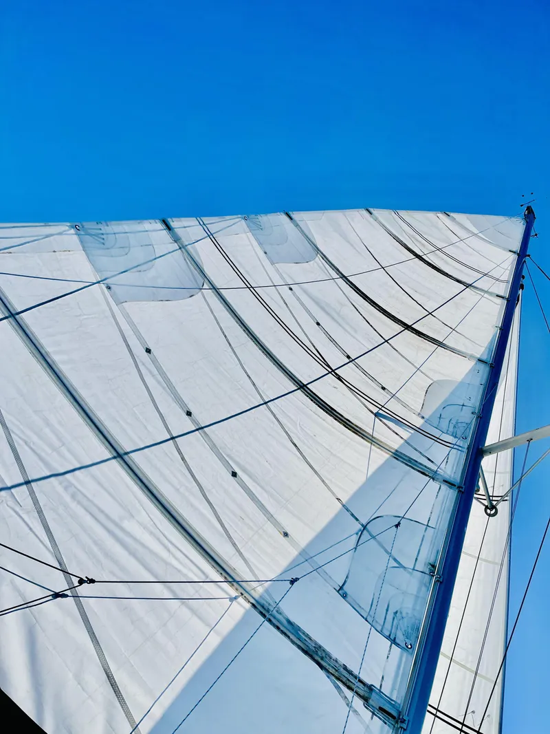 Slide: The Image of Sail of a 2014 Lagoon 380 S2 catamaran against a clear blue sky. - 5