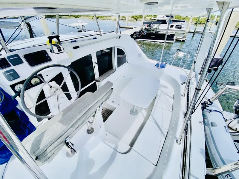 Slide: The Image of 2014 Lagoon 380 S2 catamaran cockpit with steering wheel and seating, docked at marina. - 8