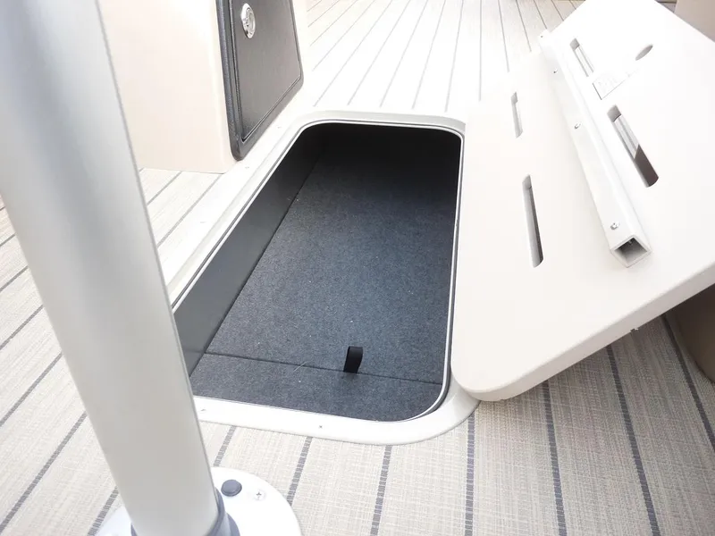 Slide: The Image of 2025 SunCatcher Select 322SS boat storage compartment with open hatch on deck. - 12