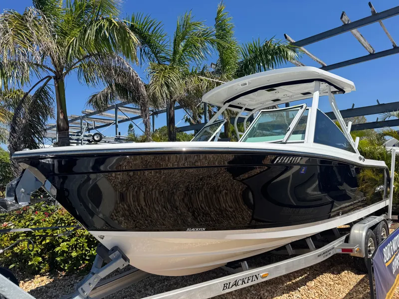 Slide: The Image of 2022 Blackfin 252 DC boat on trailer, surrounded by palm trees. - 14