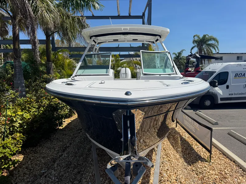 Slide: The Image of 2022 Blackfin 252 DC boat displayed outdoors with palm trees and vehicles in the background. - 15