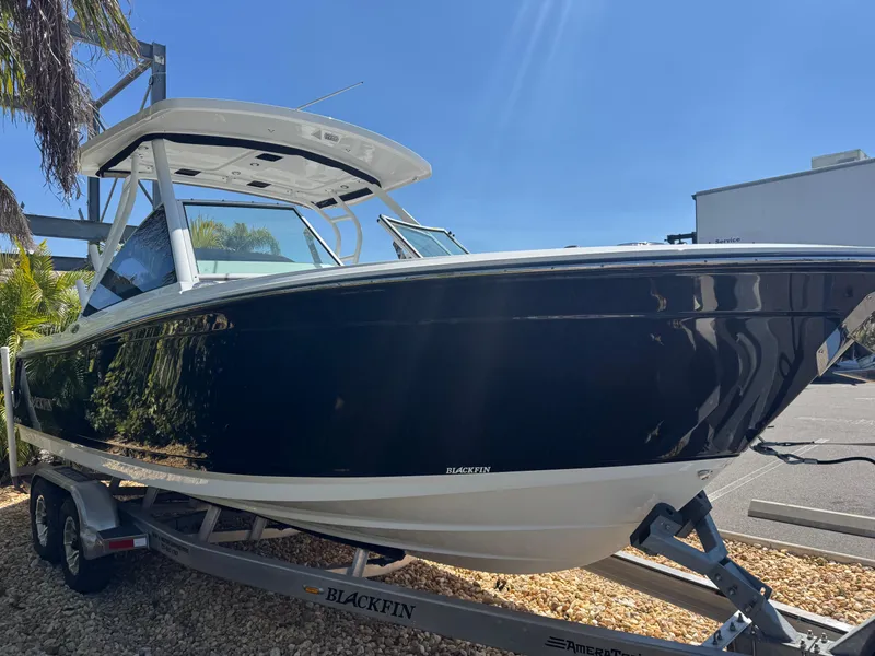 Slide: The Image of 2022 Blackfin 252 DC boat on trailer under clear blue sky. - 17