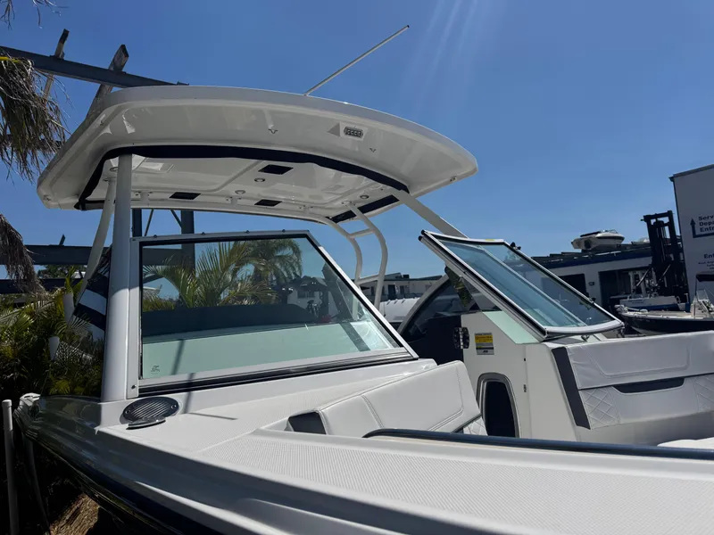 Slide: The Image of 2022 Blackfin 252 DC boat with sleek design and modern features under clear blue sky. - 18