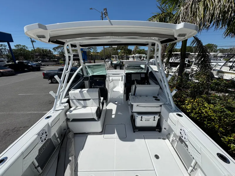 Slide: The Image of 2022 Blackfin 252 DC boat with spacious seating and modern design in a sunny marina. - 25