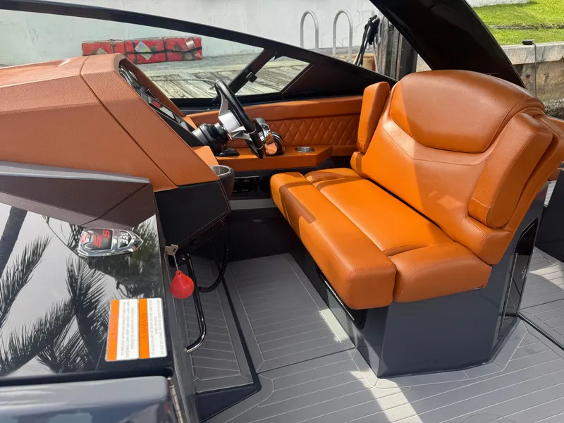 Slide: The Image of 2021 Cruisers Yachts 338 South Beach Edition Bow Rider interior with orange seating and sleek dashboard. - 15