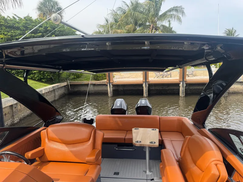 Slide: The Image of 2021 Cruisers Yachts 338 South Beach Edition Bow Rider with orange seating, docked by palm trees. - 17