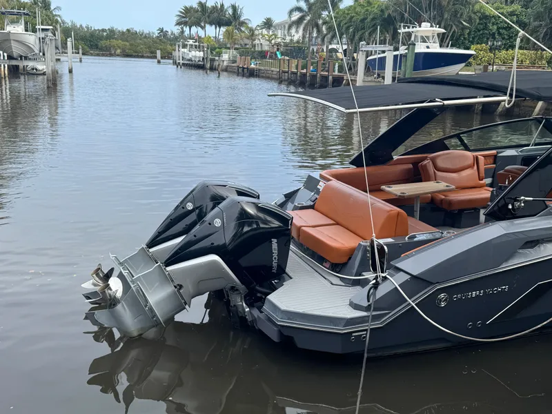 Slide: The Image of 2021 Cruisers Yachts 338 South Beach Edition Bow Rider docked on a calm waterway. - 2