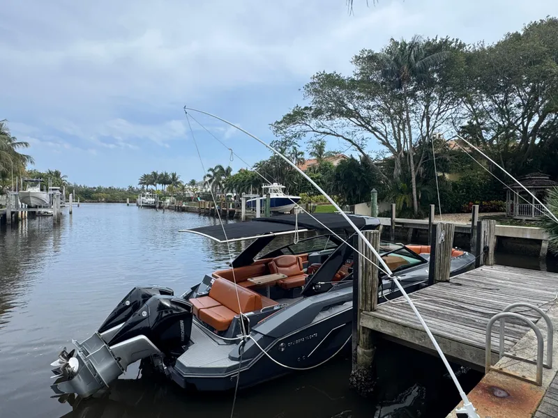 Slide: The Image of 2021 Cruisers Yachts 338 South Beach Edition Bow Rider docked by a scenic waterfront. - 3