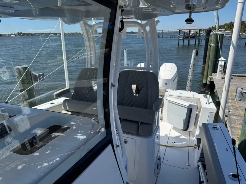 Slide: The Image of 2024 Sportsman 302 boat interior with seating, docked by the water. - 11
