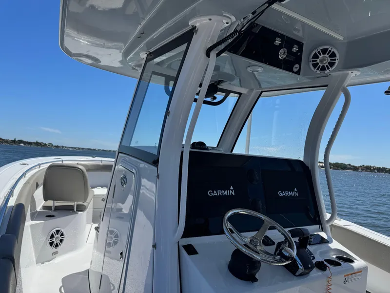 Slide: The Image of 2024 Sportsman 302 boat interior with Garmin navigation, steering wheel, and ocean view. - 12