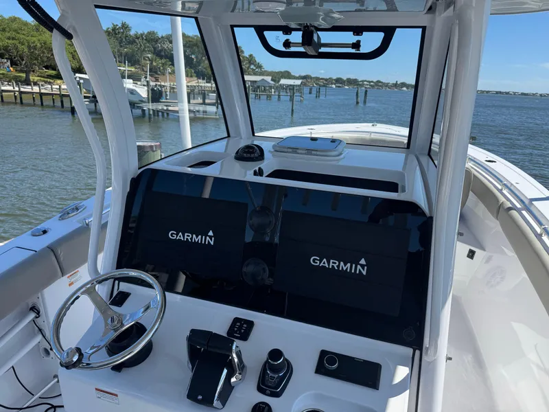 Slide: The Image of 2024 Sportsman 302 boat dashboard with Garmin navigation system, steering wheel, and controls. - 2