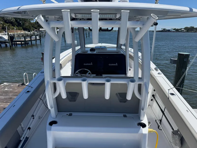 Slide: The Image of 2024 Sportsman 302 boat with rod holders and Garmin electronics, docked by the water. - 5