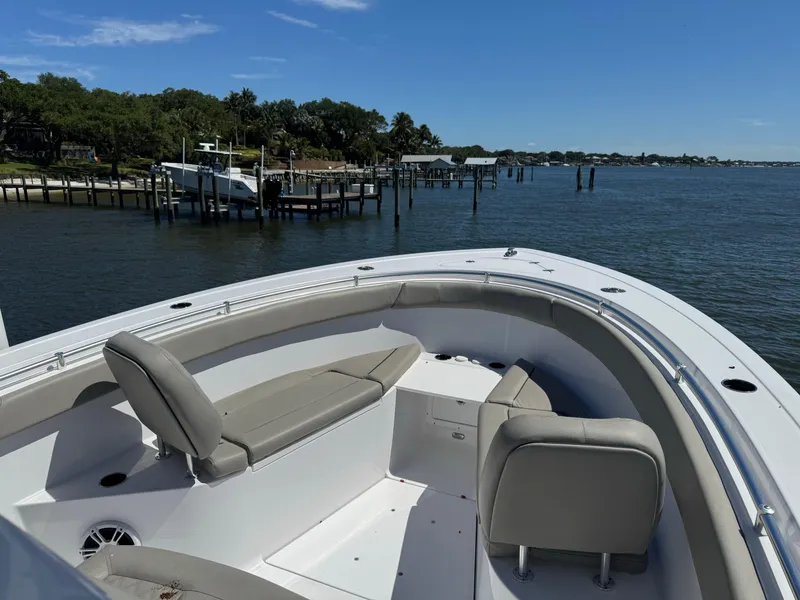 Slide: The Image of 2024 Sportsman 302 boat with spacious seating, docked near a scenic waterfront. - 6